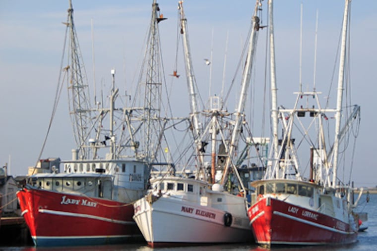 The fishing vessel Lady Mary (left), seen here moored in Cape May Harbor in 2004, sank on March 24 about 75 miles off the coast with seven people aboard. (AP Photo/U.S. Coast Guard, Seaman Daniel Kehlenbach)