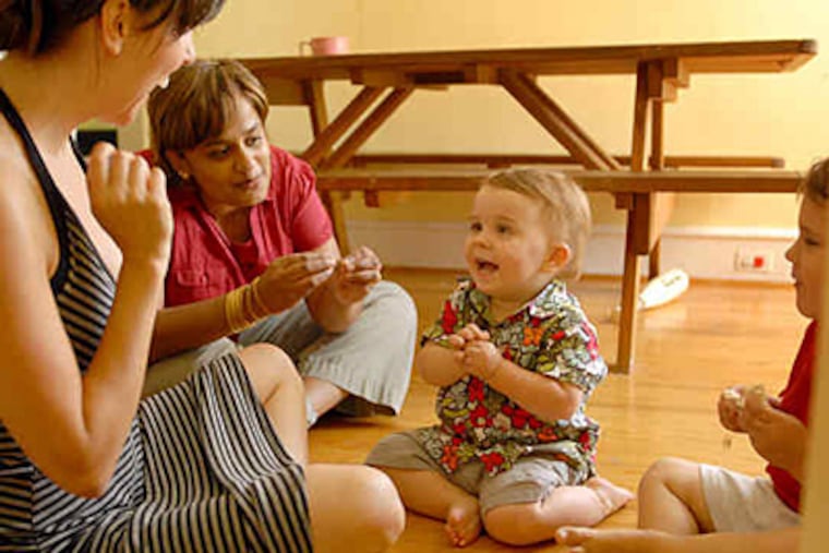Phoenix Ferragame (center), 17 months, signs "more" to his mother, Gina (left), as teacher M. Davi Chanrasekaran observes. Theo Ferragame (right), 3, verbalizes well but signs sometimes. (Tom Gralish / Staff)