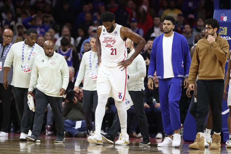 The Sixers' Joel Embiid hobbling off the court after a hard fall against the Minnesota Timberwolves at the Wells Fargo Center on Nov. 19.