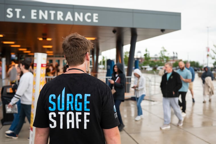 A Life Surge staff person works outside the 11th Street Entrance as attendees enter the Wells Fargo Center on Saturday, May 31, 2025.