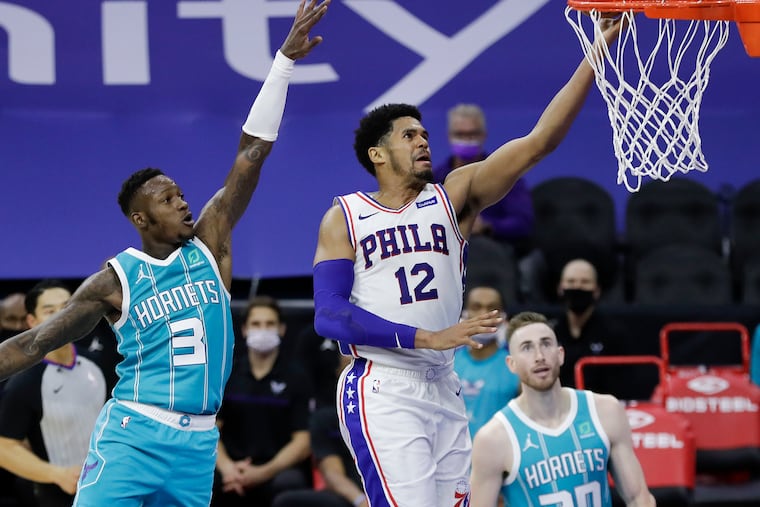 Sixers forward Tobias Harris lays up the ball past Hornets guard Terry Rozier (left) and forward Gordon Hayward.