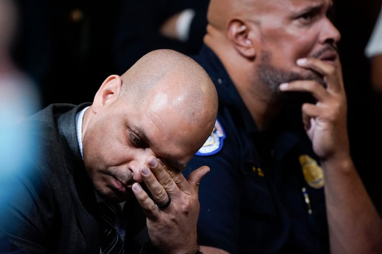 Capitol Police Sgts. Aquilino Gonell (left) and Harry Dunn react as they watch a video of the Jan. 6, 2021, attack on the U.S. Capitol during a congressional hearing in 2022.