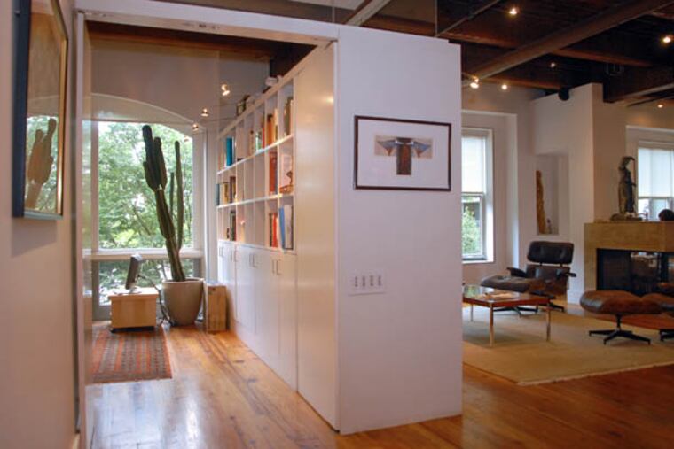 This custom bookcase/cabinet serves as a divider between the living room and office of a home in Washington Square. Other ways to create privacy include decorative screens or curtains.