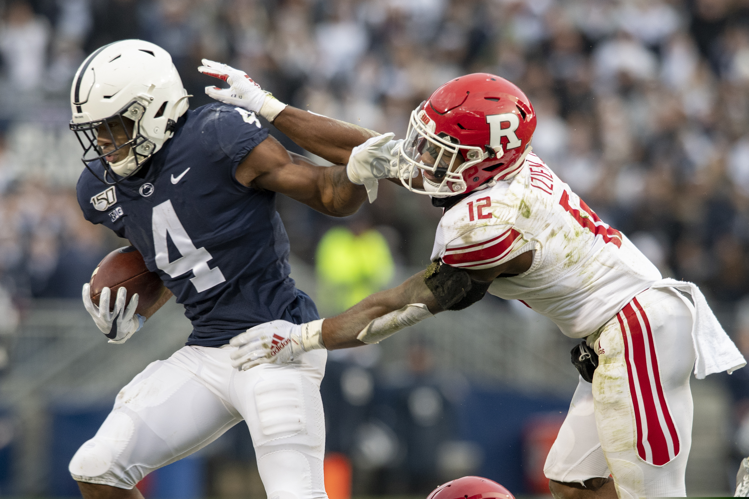 Penn State running back Journey Brown stiff arms Rutgers defensive back Christian Izien in the first quarter.