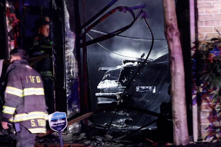Voorhees firefighters put water on hotspots in the garage area of a home at 10 Fairway Drive in Voorhees on Dec. 24, 2021. The two-alarm fire involved the home of Sixers point guard Tyrese Maxey.