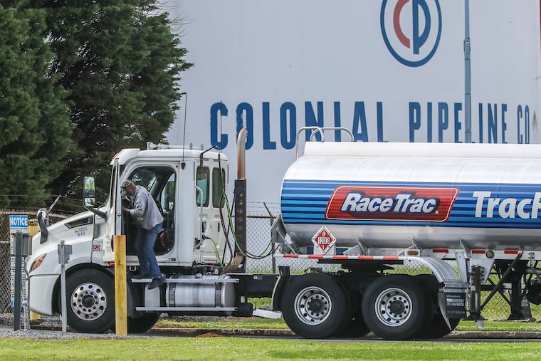 Gasoline tankers pass by the Colonial Pipeline storage tanks in Austell, Ga., on Monday, May 10, 2021, as they enter the Marathon Powder Springs Terminal.