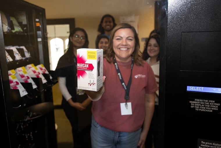 Jackie Recktenwald, the University of Pennsylvania's director of well-being initiatives, shows a box of Narcan at the vending machine inside the Arch building on Penn's campus Friday.