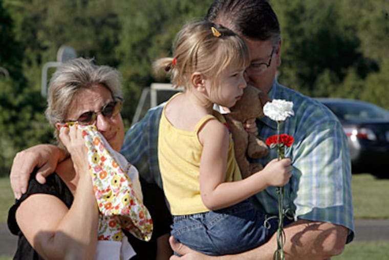 It was an emotional day for Katja and James O'Conner, with 3-year-old daughter Erika. The O'Conners, of Newtown, lost several friends and colleagues in the Sept. 11, 2001, attacks. More than 50 who died in the attacks were from the region. (AKIRA SUWA / Inquirer)