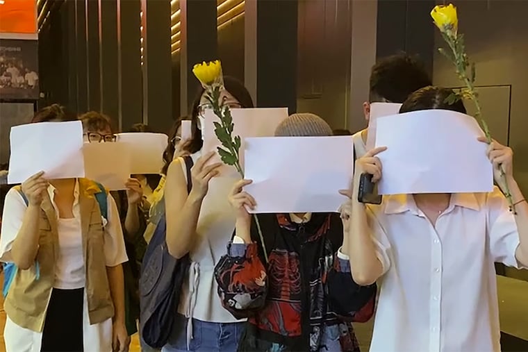 Protesters in Hong Kong hold up blank sheets of white paper and chant “oppose dictatorship” during a demonstration earlier this week against China’s anti-virus controls.