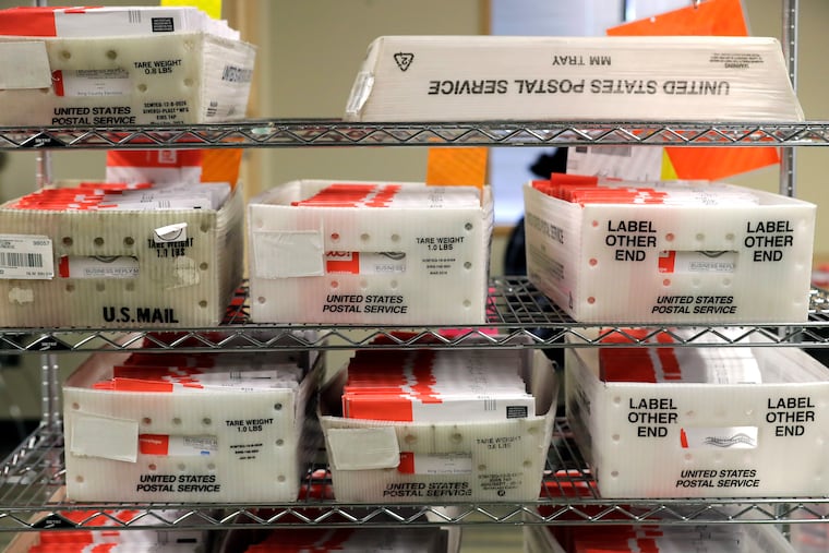 Vote-by-mail ballots are shown in U.S. Postal service sorting trays, Wednesday, Aug. 5, 2020, at the King County Elections headquarters in Renton, Wash., south of Seattle.