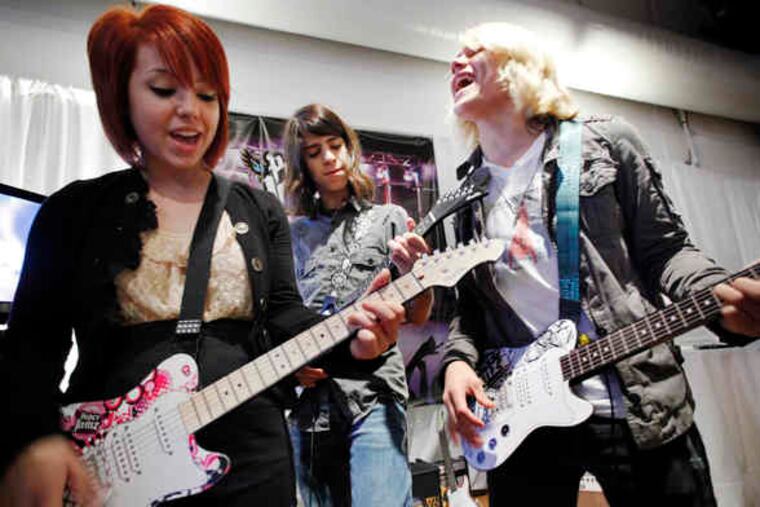 The group Kicking Daisies, including (from left) Carly Kalafus, Ben Spremulli, and Duran Visek, performing its first single, "Keeping Secrets,"in New York. The group plays Paper Jamz guitars and drums, from WowWee Toys, named to Time to Play's 2010 holiday most-wanted list.