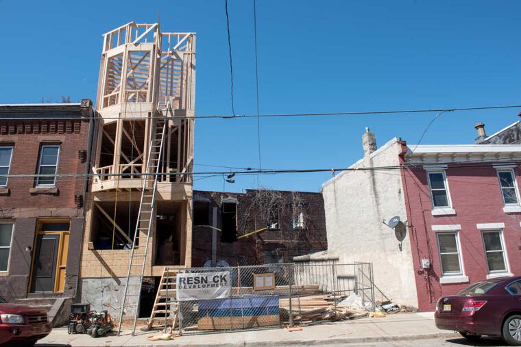 A three-story property is framed on N. 27th Street in Brewerytown in 2017. The neighborhood, once the site of significant disinvestment, has seen plenty of new construction in recent years as developers have purchased and flipped scores of properties and lots.