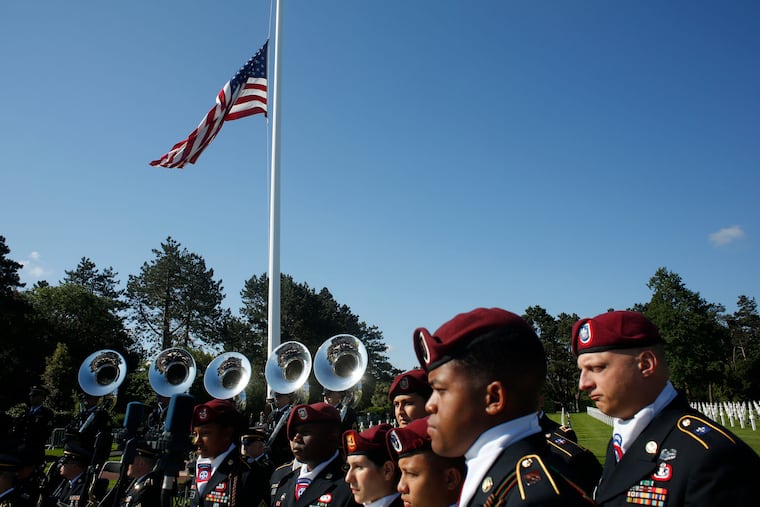 US Army soldiers, based in Germany, stand near the American flag prior to a ceremony to mark the 75th anniversary of D-Day at the Normandy American Cemetery in Colleville-sur-Mer, Normandy, France, Thursday, June 6, 2019. World leaders are gathered Thursday in France to mark the 75th anniversary of the D-Day landings.
