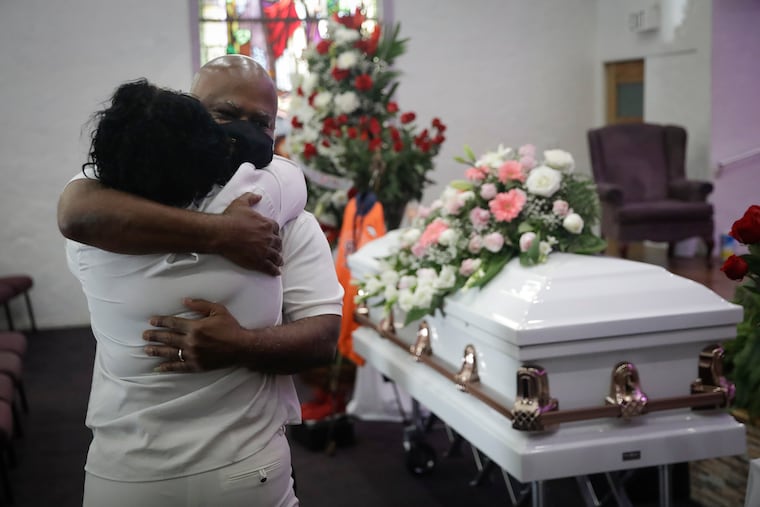 Darryl Hutchinson, facing camera, is hugged by a fellow relative during a funeral service for Lydia Nunez, who was Hutchinson's cousin, Tuesday, July 21, 2020, at the Metropolitan Baptist Church in Los Angeles. Nunez died from COVID-19.