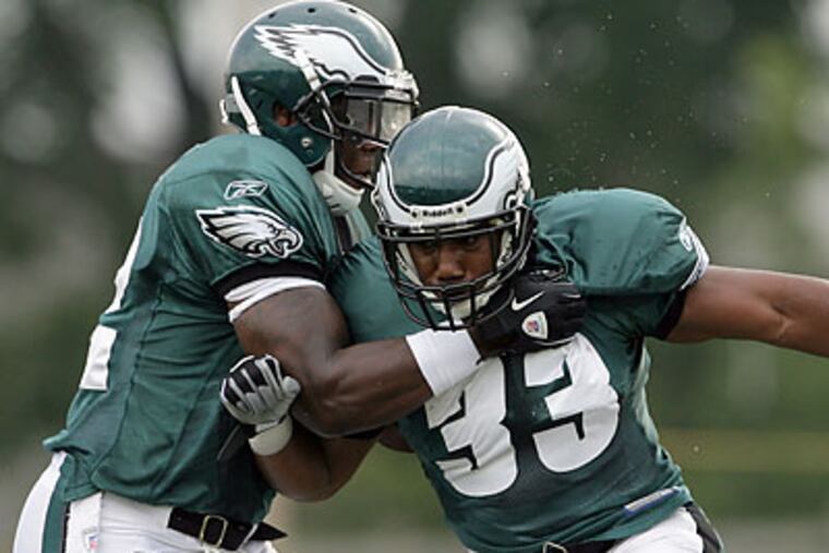 J.J. Arrington (right) tried to run past Dwayne Wright during one of Sunday's practice sessions. (Yong Kim/Staff Photographer)