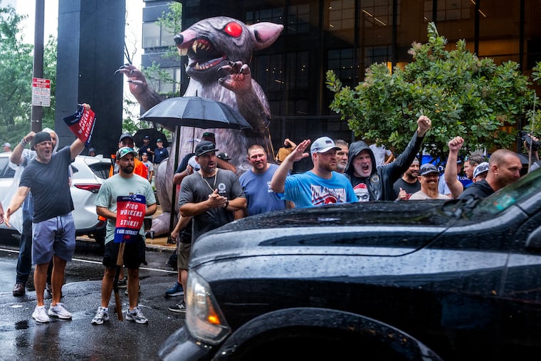 Striking Peco employees, part of IBEW Local 614, picket outside the company’s headquarters as one lane of traffic passes on Market Street Monday.