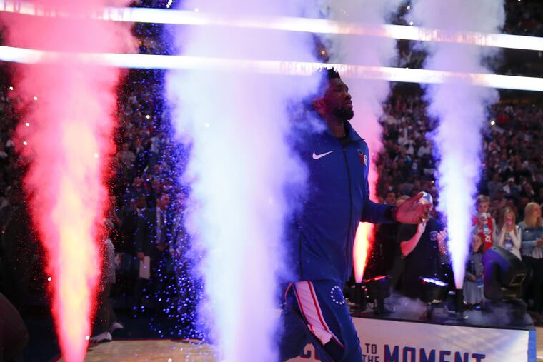 Joel Embiid runs through smoke during player introductions before the Sixers home opener in October.