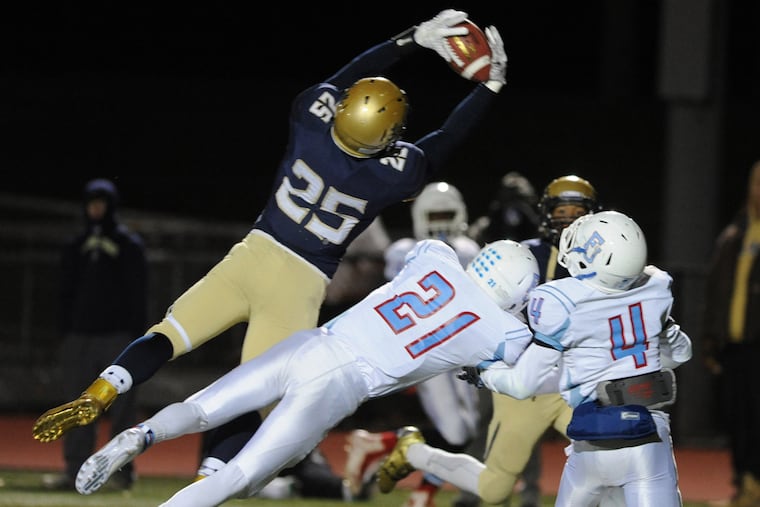 La Salle's Nick Rinella, left, intercepts a pass intended for La Salle's Justin Gies, center, and P.J. Smith, right in the second quarter of play in the Catholic League AAA Semifinal game Saturday, Nov. 14, 2015 in Plymouth Meeting, Pa.