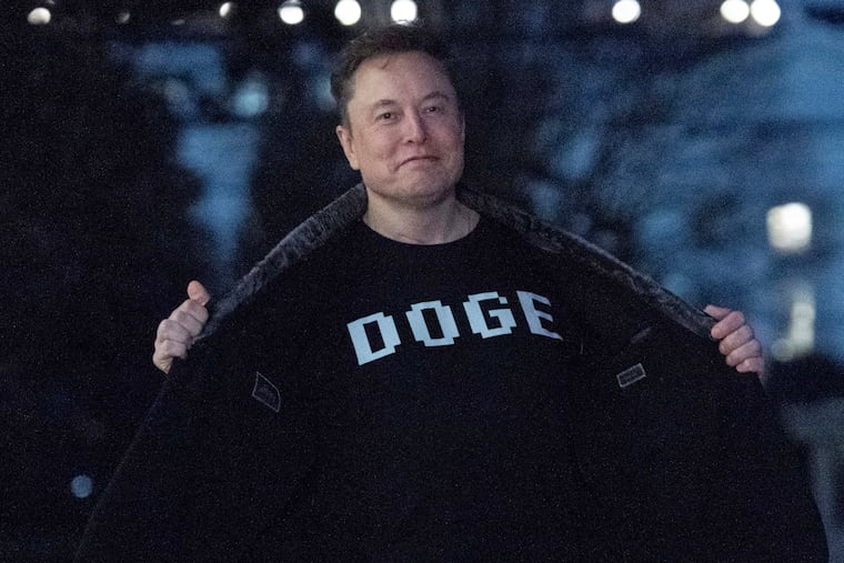 Elon Musk flashes his T-shirt to the media as he walks on the South Lawn of the White House, in March.