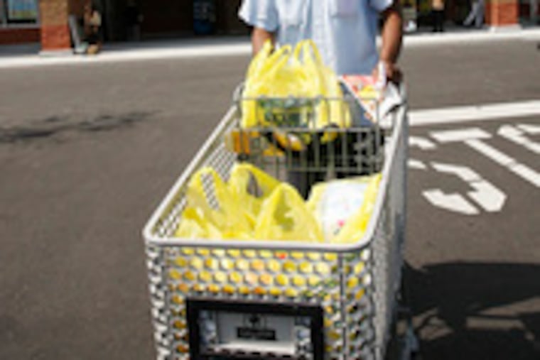 Dennis Carty wheels his purchases out of the new ShopRite at 52nd and Jefferson streets in West Philadelphia yesterday. One neighbor said it's been 20 years since the area had a grocery store.