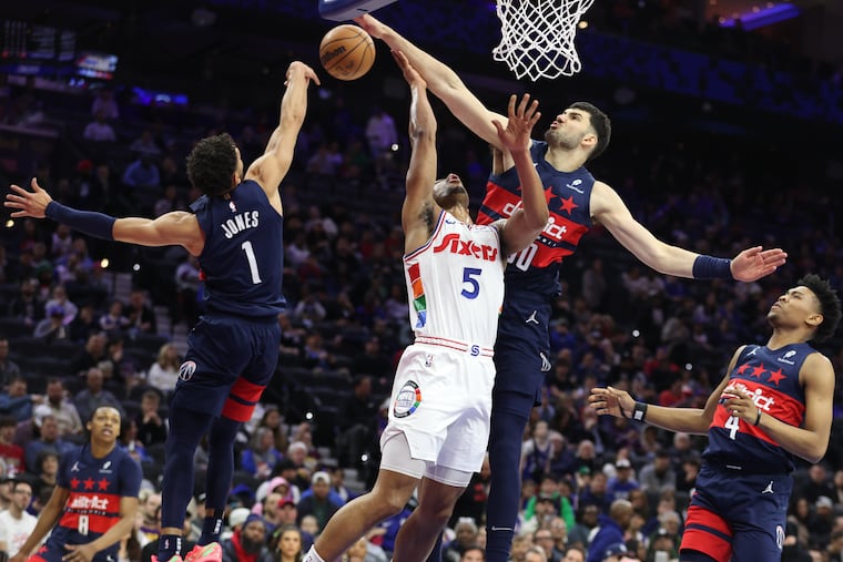 Sixers' Quentin Grimes (center) has his shot blocked by Wizards' Tristan Vukcevic during the first half of their game on Wednesday night.