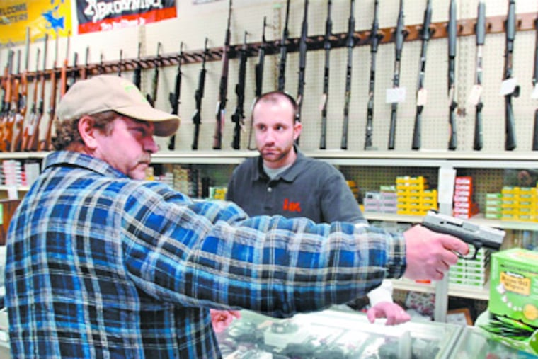 Ben Stipe (left), 49, Oxford, tries out a .45 caliber Taurus PT145handgun as Targetmaster general manager Bob Bonnett looks on. ( ClemMurray / Staff Photographer )
