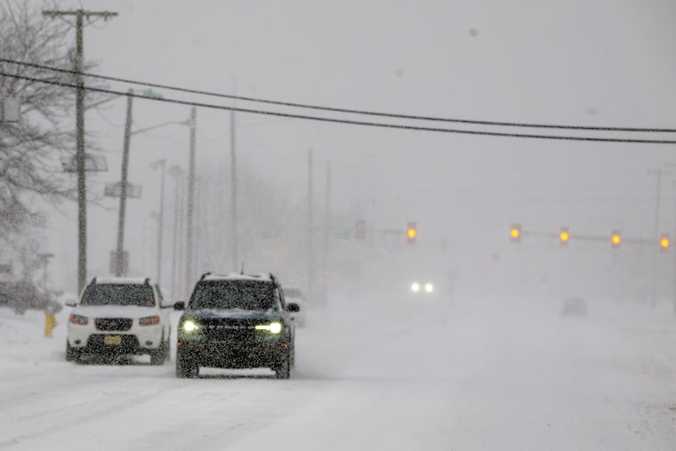 A few cars drive on Haddonfield Road in Cherry Hill early Sunday morning, Jan. 25, 2026, as heavy snow bands move through the region.