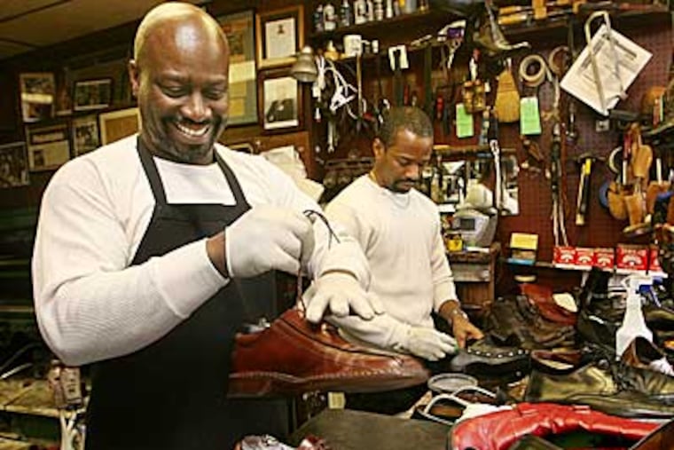 Brothers Jerry (left) and Cliff Burrell in their shoe-shine establishment on 40th Street near Sansom. (Jessica Griffin / Staff Photographer)