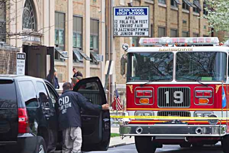 An overnight fire at Lansdowne's Penn Wood High School forced officials to cancel classes Thursday. Here, crime scene invesitgators and fire personnel outside the school.( ED HILLE / Staff Photographer )