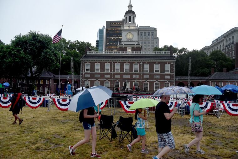 A few music fans remain on the mall after the Philly Pops annual patriotic concert at Independence Hall was cancelled due to inclement weather conditions July 3, 2018. The POPS on Independence was to be part of the city's July Fourth Wawa Welcome America celebration. TOM GRALISH / Staff Photographer