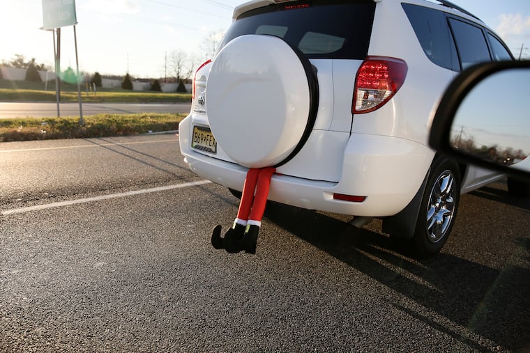 The legs of an elf, or maybe even Santa himself, stick out from the back of a woman's vehicle as she drives along on Rt 73 in Mount Laurel, N.J. on Dec. 2, 2020.