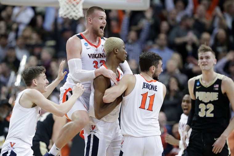 Virginia's Jack Salt (33) celebrates with teammates Mamadi Diakite and Ty Jerome (11) as Purdue's Matt Haarms (32) watches after Diakite hit a shot to send the game to overtime of the men's NCAA Tournament college basketball South Regional final game, Saturday, March 30, 2019, in Louisville, Ky. (AP Photo/Michael Conroy)