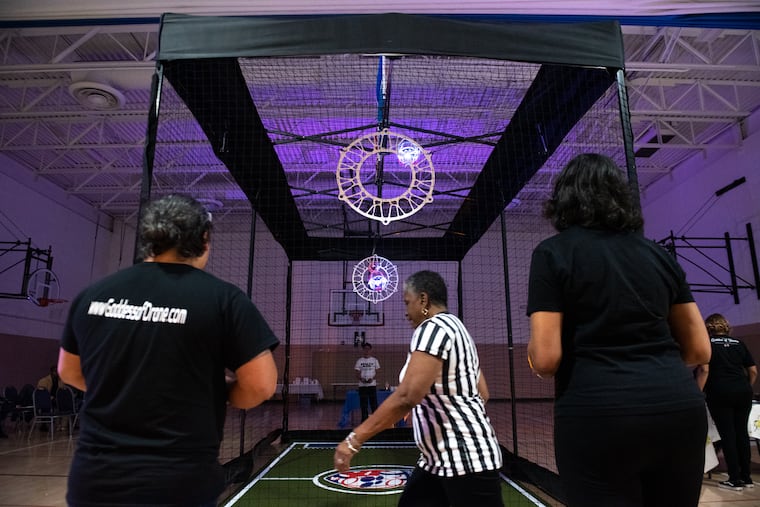 Players compete in a game at the launch party of the Philadelphia Drone Soccer League at a YMCA in West Philadelphia on Monday, Nov. 21, 2022. Opposing teams fly RC quadcopter drones in protective cages designed for full-contact gameplay as they ram and block each other in midair.