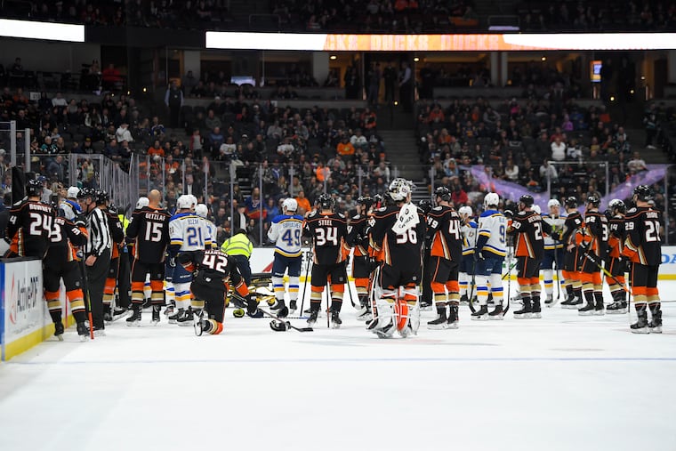 Members of the St. Louis Blues and Anaheim Ducks gather on the ice as Blues defenseman Jay Bouwmeester, who suffered a medical emergency, is worked on by medical personnel during the first period.