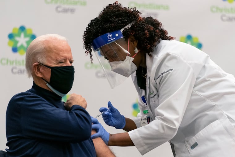 Then-President-elect Joe Biden receives his first dose of the coronavirus vaccine from Nurse partitioner Tabe Mase in December 2020.