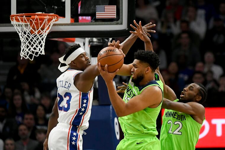 The Minnesota Timberwolves' Karl-Anthony Towns pulls down a defensive rebound against Jimmy Butler during the first half.