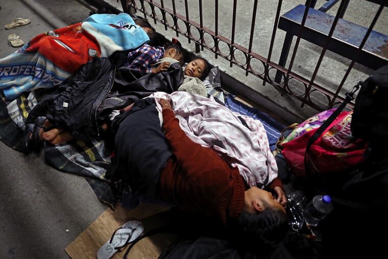 A migrant family including three small children camps near a border bridge in Ciudad Juarez, Mexico.