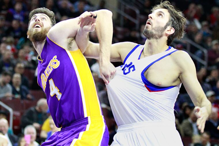 Ryan Kelly, left, of the Lakers grabs the jersey of Furkan Aldemir. (Charles Fox/Staff Photographer)