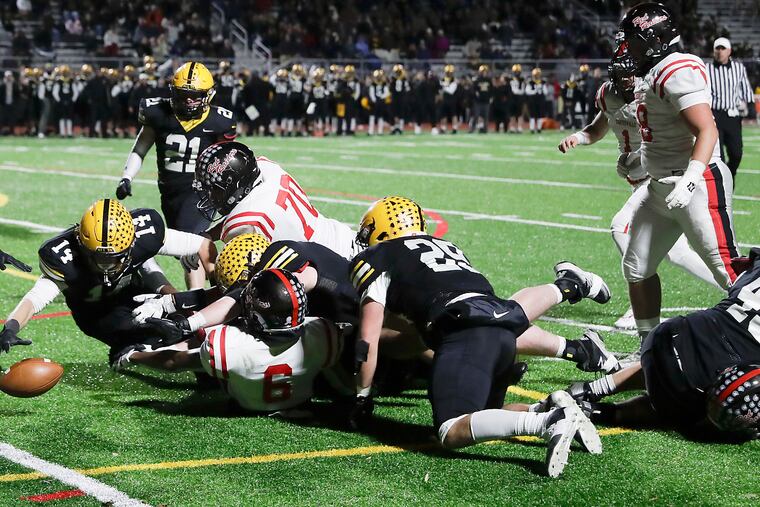 Football players from Central Bucks West High (black uniforms) and Coatesville scramble to recover a fumble during the PIAA District 1, Class 6A quarterfinals on Nov. 8, 2019.
