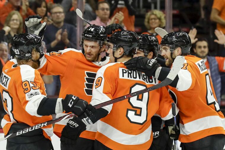 Flyers center Sean Couturier (second from left) celebrates his goal in an early-season win over Washington. The teams will meet Sunday at 5 p.m. at the Wells Fargo Center.