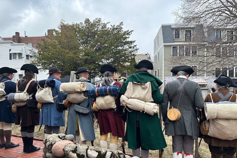 Revolutionary War reenactors line up outside St. Augustine Chapel and Cemetery in South Boston, Tuesday, March 17, 2026, before firing muskets during Evacuation Day commemorations marking the 250th anniversary of the British withdrawal from Boston. (AP Photo/Leah Willingham)