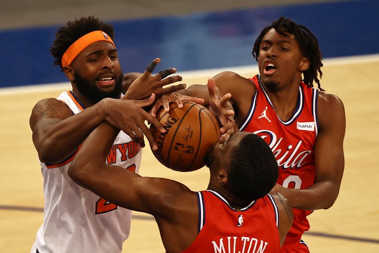The Knicks' Mitchell Robinson (left) and Sixers Tyrese Maxey (right) and Shake Milton go after a rebound in the second half.