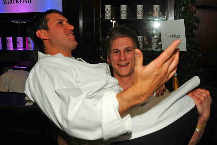 Chef Jason Cichonski hoisting chef Charles "Chip" Roman at Wednesday's Philly Cooks benefit for the Ronald McDonald House at the Crystal Tea Room. The pair will open a Chestnut Hill restaurant called Mica in March.