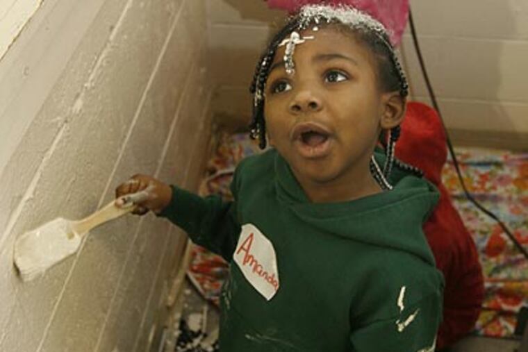 Amanda Jones works on painting a wall at the George Washington Carver Community Center in Norristown. (Charles Fox/Staff Photographer)