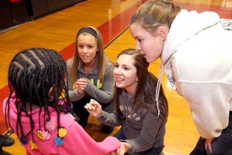 Eighty-Five students participated in the Woodbury Junior-Senior High School's annual Day of Service to honor the Rev. Dr. Martin Luther King Jr. A small number of students helped out at tthe YMCA of Gloucester County. L-R: Nicole Dunca, Emily Atkinson, and Laura Knechi comfort Janiah Hamilton, left foreground, after she was hit in the face with a ball. (The YMCA has releases for the children) ( Charles Fox / Staff Photographer )