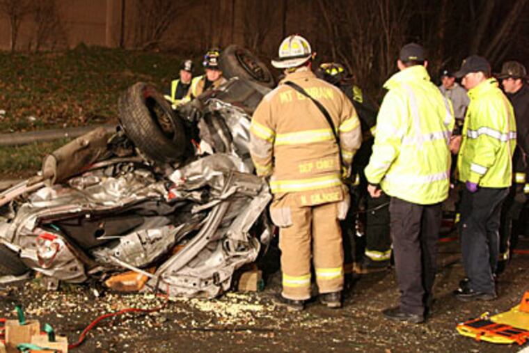 Emergency personnel look over the wreckage from a fiery car crash on I-76 in Camden County. (Steve Skipton / PhillyFireNews.com)