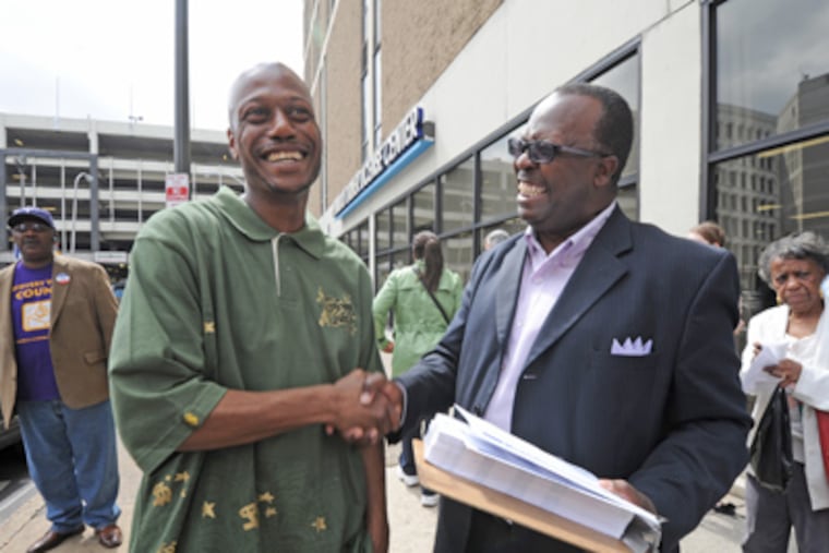 At a PennDot motor vehicle office in Center City, Kelvin Croom (left) of Philadelphia, after getting his voter ID, is congratulated by John Jordan of NAACP Pennsylvania.