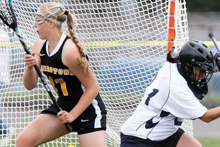 Moorestown's Kayla Pruitt distracts the Shawnee goalie Lily Argyle enough to allow a shot by teammate Sydney Dalmass into the goal during the first half of girls field hockey in Medford, May 7, 2013. (David M Warren/Staff Photographer)