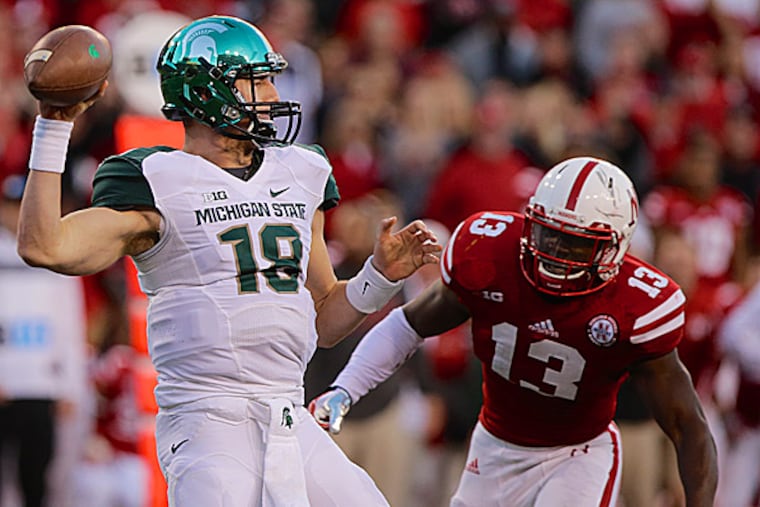 Michigan State quarterback Connor Cook throws under pressure from Nebraska linebacker Zaire Anderson. (Nati Harnik/AP)