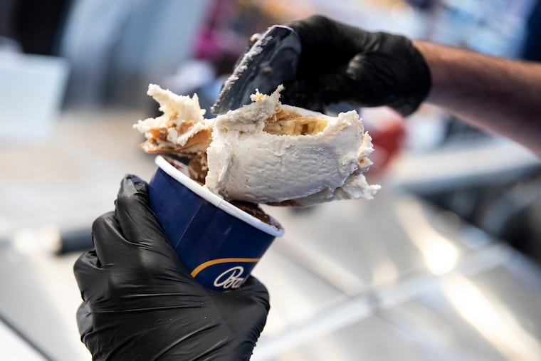 Alex Strange scoops peanut butter swirl ice cream into a pint at Bassetts Ice Cream in the Reading Terminal Market in Philadelphia, Pa. on Thursday, June 1, 2023.